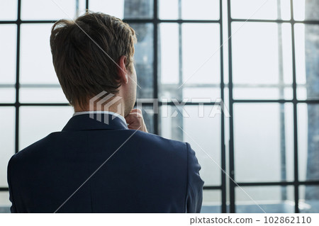 Rear view portrait of a businessman standing in the office Rear view portrait of a businessman standing in the office 102862110