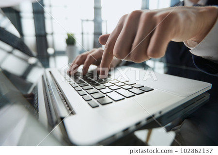Young man presses his finger on the computer at the table in the office, close-up. 102862137