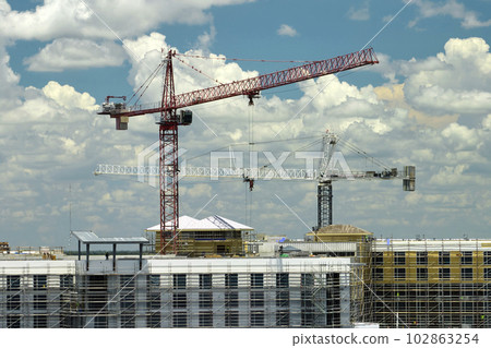 Tower cranes and frame structure of high residential apartment buildings at construction site. Real estate development 102863254