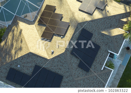 Standard american residential house with rooftop covered with solar photovoltaic panels for producing of clean ecological electrical energy in suburban rural area. Concept of autonomous home 102863322