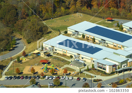 Roof of american school building covered with photovoltaic solar panels for production of electric energy. Renewable energy concept 102863350
