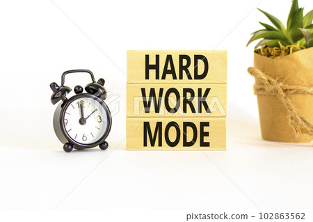 Hard work mode symbol. Concept words Hard work mode on wooden block on a beautiful white table white background. Black alarm clock. Business and Hard work mode concept. Copy space. 102863562