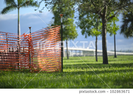 Protective restriction barrier at industrial construction site. Safety mesh fence for pedestrians 102863671