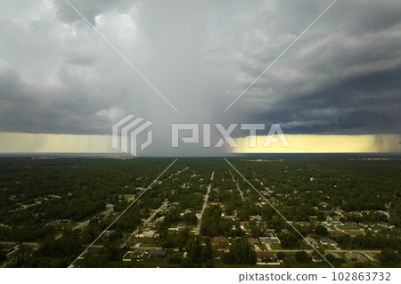 Landscape of dark ominous clouds forming on stormy sky during heavy thunderstorm over rural town area 102863732