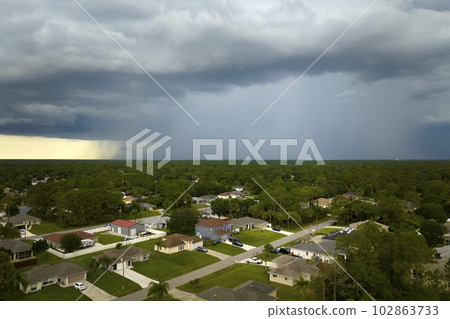 Landscape of dark ominous clouds forming on stormy sky during heavy thunderstorm over rural town area Landscape of dark ominous clouds forming on stormy sky during heavy thunderstorm over rural town area 102863733