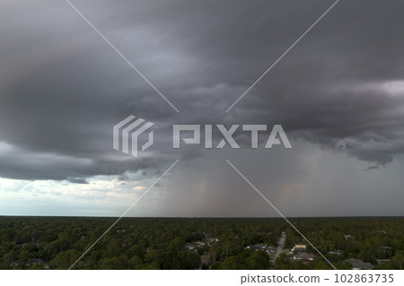 Landscape of dark ominous clouds forming on stormy sky before heavy thunderstorm over rural town area Landscape of dark ominous clouds forming on stormy sky before heavy thunderstorm over rural town area 102863735