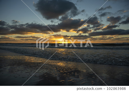 Evening landscape of sea water waves crushing on sandy beach at sunset Evening landscape of sea water waves crushing on sandy beach at sunset 102863986