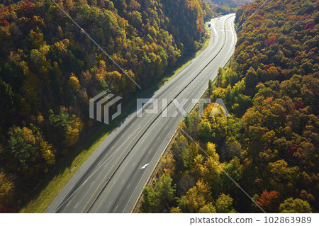 Empty free of vehicles I-40 freeway road leading to Asheville in North Carolina thru Appalachian mountains with yellow fall forest. High gas prices and energy crisis concept 102863989