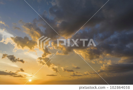 Colofrul clouds brightly illuninated by setting sun on evening sky. Changing cloudscape weather at sunset Colofrul clouds brightly illuninated by setting sun on evening sky. Changing cloudscape weather at sunset 102864038