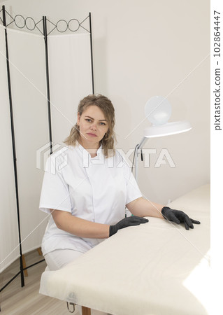 Portrait Of Electrologist, Smiling Beauty Specialist Looking At Camera In Beauty Salon. Vertical Plane. Authentic Photo Of Aesthetic Specialist Providing Skin Care Services 102864447