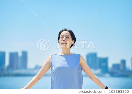 A woman with a relaxed expression under the blue sky A woman with a relaxed expression under the blue sky 102865260