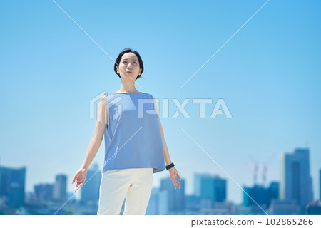 A woman with a relaxed expression under the blue sky A woman with a relaxed expression under the blue sky 102865266