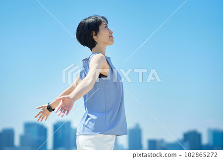 A woman with a relaxed expression under the blue sky A woman with a relaxed expression under the blue sky 102865272