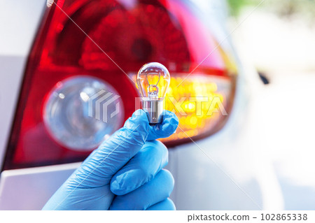 Close up of a bulb with car tail light in the background Close up of a bulb with car tail light in the background 102865338