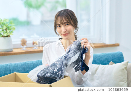 A woman checking mail-order luggage at home 102865669