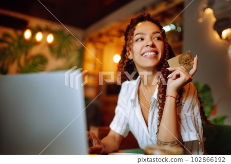Young woman sitting at cafe making online shopping, using credit card and laptop. Online shopping 102866192