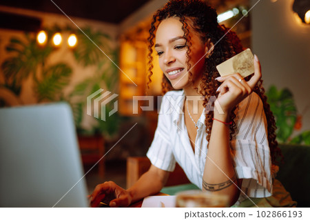 Young woman sitting at cafe making online shopping, using credit card and laptop. Online shopping 102866193
