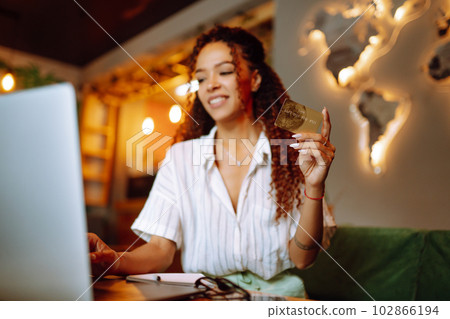 Young woman sitting at cafe making online shopping, using credit card and laptop. Online shopping Young woman sitting at cafe making online shopping, using credit card and laptop. Online shopping 102866194