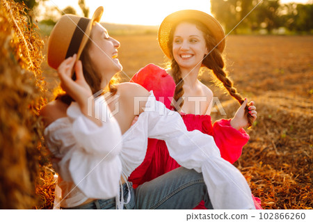 Two young women having fun near haystack. Fashion concept. Summer concept. Two young women having fun near haystack. Fashion concept. Summer concept. 102866260