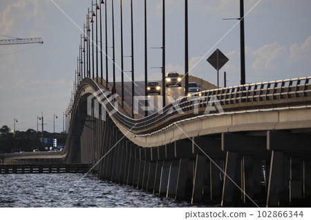 Barron Collier Bridge and Gilchrist Bridge in Florida with moving traffic. Transportation infrastructure in Charlotte County connecting Punta Gorda and Port Charlotte over Peace River Barron Collier Bridge and Gilchrist Bridge in Florida with moving traffic. Transportation infrastructure in Charlotte County connecting Punta Gorda and Port Charlotte over Peace River 102866344