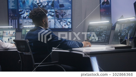 African American operator monitors CCTV cameras 102866368