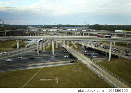 American freeway intersection with fast driving cars and trucks. View from above of USA transportation infrastructure 102866393
