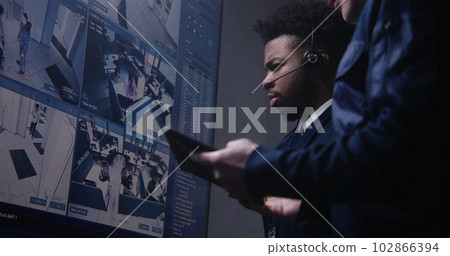 Multi ethnic coworkers in surveillance center 102866394