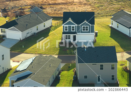 Aerial view of tightly packed homes in South Carolina residential area. New family houses as example of real estate development in american suburbs Aerial view of tightly packed homes in South Carolina residential area. New family houses as example of real estate development in american suburbs 102866443