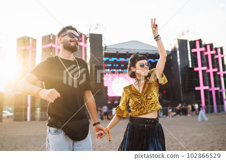 Lovely couple having fun at festival. Young friends with beer at beach party. Summer holiday, vacation. Lovely couple having fun at festival. Young friends with beer at beach party. Summer holiday, vacation. 102866529