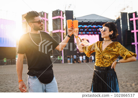 Lovely couple having fun at festival. Young friends with beer at beach party. Summer holiday, vacation. 102866537