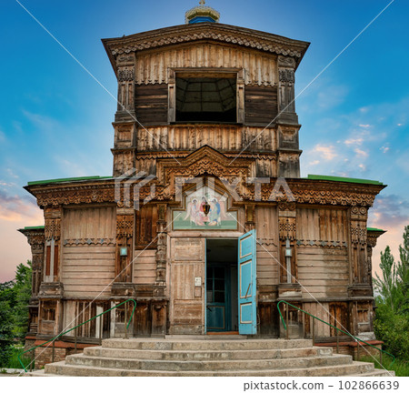 Karakol, Kyrgyzstan - May 2022: Wooden Church of Saint Trinity is a stunning example of 19th-century Russian Orthodox architecture, featuring intricate wooden carvings and vibrant frescoes. 102866639