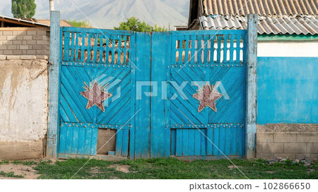 Kyrgyzstan - May 2022: Traditional wooden door in a small rural village in foothill of Pamir Mountains, a beautiful and intricate part of the country's architecture with unique design and motif 102866650