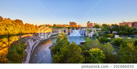 Stunning waterfall at golden hour in city of Rochester New York with downtown in background 102866850