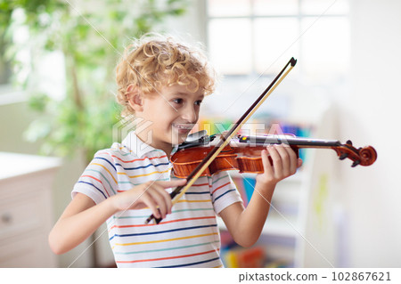Child playing violin. Remote learning. Child playing violin. Remote learning. 102867621