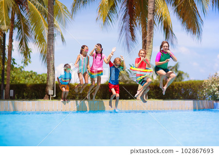 Kids jump into swimming pool. Summer water fun. Kids jump into swimming pool. Summer water fun. 102867693