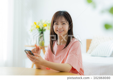 A woman looking at her smartphone in the living room 102868080