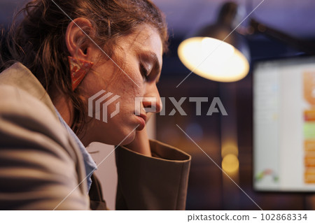 Tired businesswoman sleeping at desk table in startup office, working late at night at marketing strategy. Overworked business owner checking financial graphs report, falling asleep at job 102868334