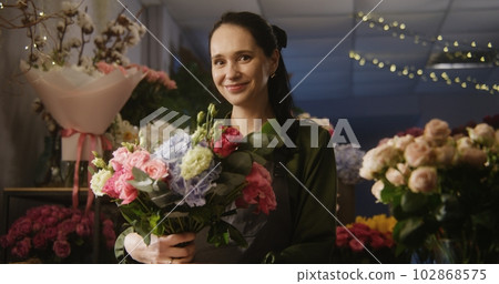 Female florist keeps in hands beautiful bouquet Female florist keeps in hands beautiful bouquet 102868575