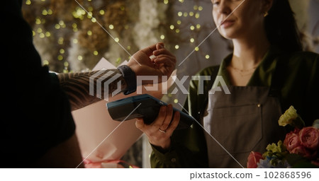 Man pays for flowers with contactless payment using smart watch 102868596