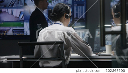 Female security officer controls CCTV cameras with AI facial recognition 102868600
