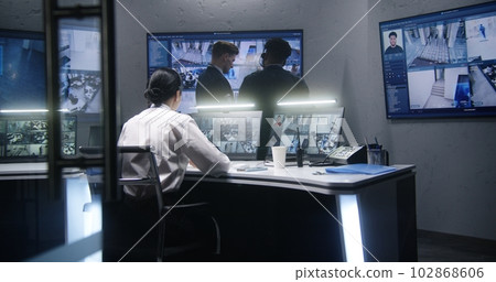 Multi ethnic employees talk in surveillance center Multi ethnic employees talk in surveillance center 102868606