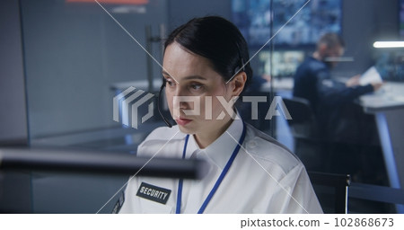 Female worker of security monitoring center in headset Female worker of security monitoring center in headset 102868673
