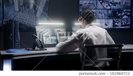 Female officer controls CCTV cameras using tablet 102868722