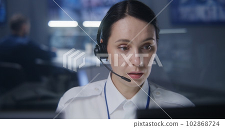 Female worker of security monitoring center in headset Female worker of security monitoring center in headset 102868724