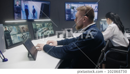 Security officer touches tablet and controls CCTV cameras Security officer touches tablet and controls CCTV cameras 102868730