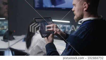 Male officer zooms and controls security cameras Male officer zooms and controls security cameras 102868732