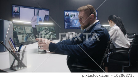 Male security operator controls CCTV cameras Male security operator controls CCTV cameras 102868733
