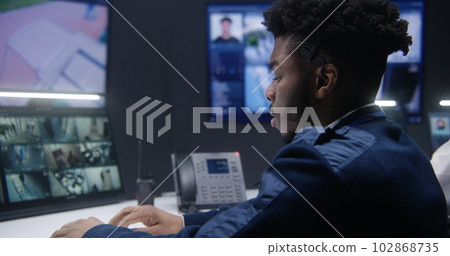 African American officer controls CCTV cameras African American officer controls CCTV cameras 102868735