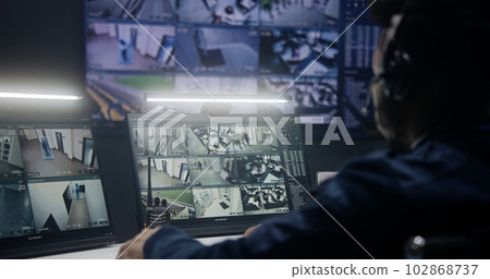 Officer in headset controls security cameras Officer in headset controls security cameras 102868737