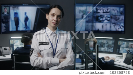 Portrait of female security officer in police monitoring center Portrait of female security officer in police monitoring center 102868738